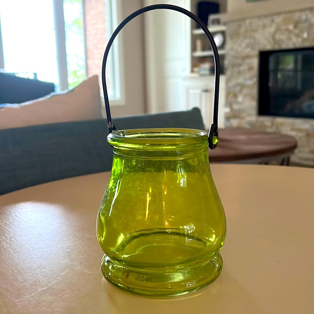 Small green lantern style votive holder.